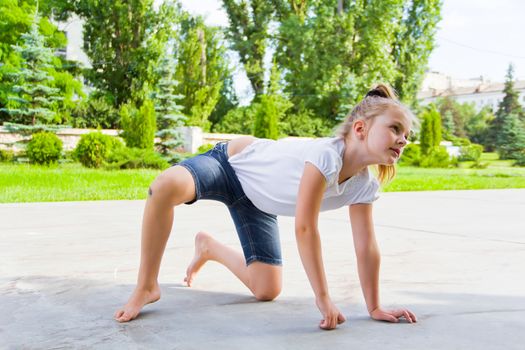 Cute girl draws chalk on asphalt in summer