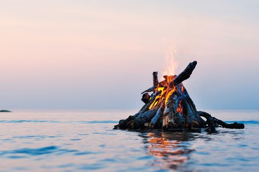 Bright campfire on the sea surface