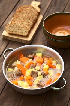 Pot filled with traditional Hungarian soup called Gulyasleves made of beef, potato, carrot, onion, csipetke (homemade pasta) and seasoned with salt and paprika (Selective Focus, Focus one third into the soup)