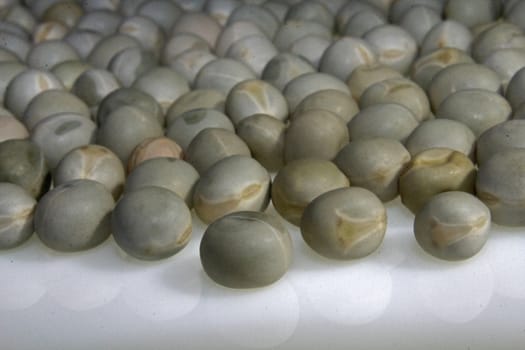 Close up view of scattered dried green pea on white background