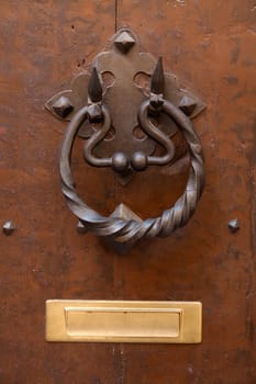 Old wooden door with metallic handle knocker
