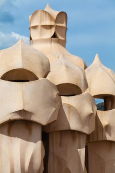 BARCELONA, SPAIN - APR 14: Chimneys like masked soldiers on the roof of La Pedrera or Casa Mila designed by Antoni Gaudi, on April 14, 2012 in Barcelona, Spain. La Pedrera was built in 1906-1910.