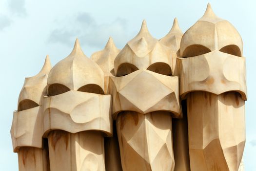 BARCELONA, SPAIN - APR 14: Chimneys like masked soldiers on the roof of La Pedrera or Casa Mila designed by Antoni Gaudi, on April 14, 2012 in Barcelona, Spain. La Pedrera was built in 1906-1910.