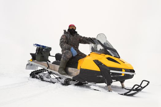 fisherman on a snowmobile rides on winter fishing
