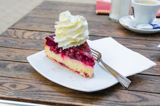 Cherry cake, fruit cake dessert, gourmet food with cream on a white plate. Shot in the cafe.