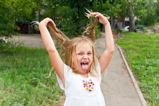 Cute beautiful girl makes faces imitate witch
