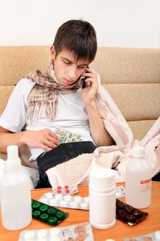 Sick Teenager with Cellphone checking the Wallet on the Sofa at the Home