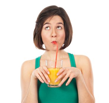 Portrait of a young woman drinking an orange juice with a straw, and looking up isolated on white