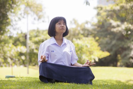 Student is sitting on the lawn. Concentration and meditation