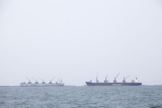 Large cargo ship Boats moored in the sea to make sense compared to the coast.