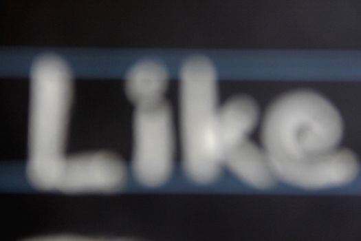 blur image of like word handwritten on black chalkboard