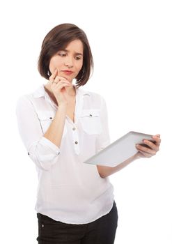 Young brunette holding and reading something on a touchpad with a wondering face, isolated on white