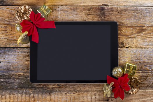 tablet pc with  christmas decorations on wooden background