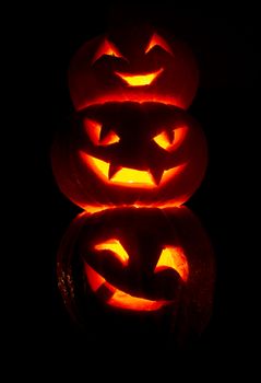 Illuminated cute halloween pumpkins isolated on black background