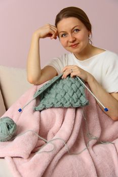 happy young woman knitting on sofa