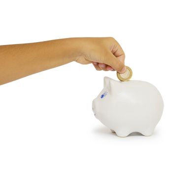 hand putting coin into a piggy bank isolated on white