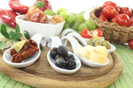 Tapas with prunes, figs and apricots on a light background