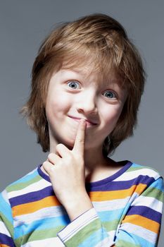 Boy Looking Thinking, Finger on his Mouth - Isolated on Gray