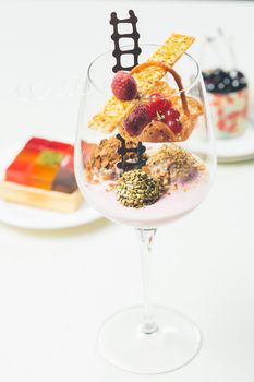 Close up of chocolate truffles with raspberry yogurt in elegant glasses. Warm colors. Shallow dof. 