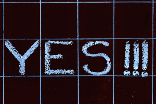 yes word handwritten on black chalkboard