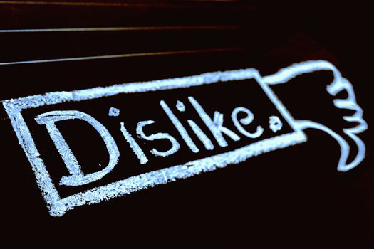 Dislike word handwritten on black chalkboard