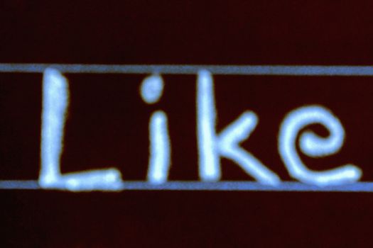 blur image of like word handwritten on black chalkboard