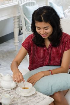 Young woman at home with a tea from a cup 