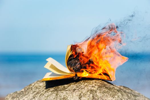 Burning book on the sea coast