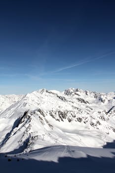 Tops of winter alp mountains at sunny day