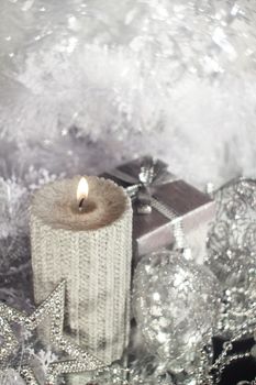 Beautiful shiny silver christmas decor and burning candle