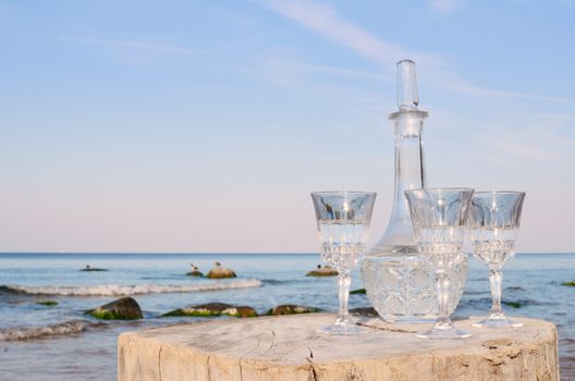 Crystal glasses and decanter on the beach