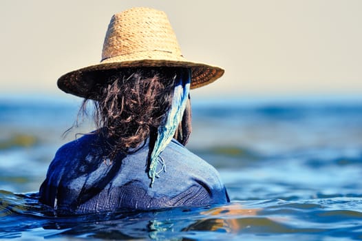 Woman with hat and wet dress in water