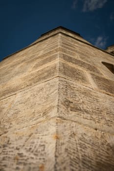 Close up vertical view of the stone tower of a castle.