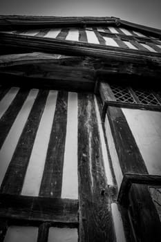 A low angle, vertical view of a striped wooden tudor house.