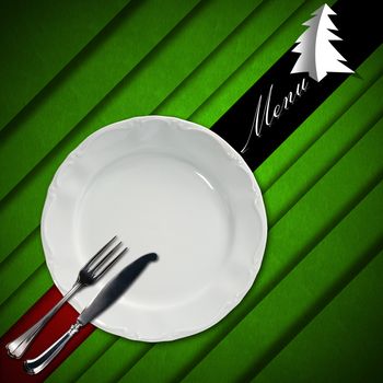 Red and green velvet background with diagonal bands and written menu, empty white plate with silver cutlery and stylized Christmas trees with shadows. Template for a Christmas food menu