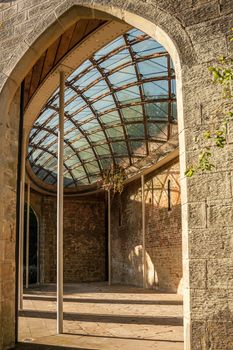 The interior of a stone brick building with a patterned glass ceiling.