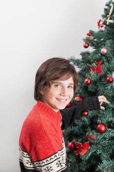 10-12, anticipation, backroud, ball, balls, boy, camera, casual, caucasian, christmas, christmastime, decorating, decorations, eyes, glass, green, holding, holiday, home, indoors, juice, look, looking, male, model, old, people, property, red, releases, situation, teenager, tree, vertical, white, years