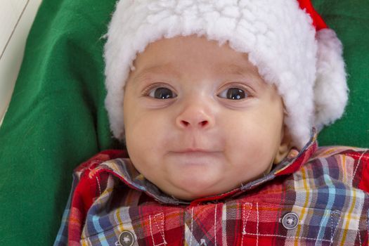 cute baby boy smiling in a santa claus hat close-up