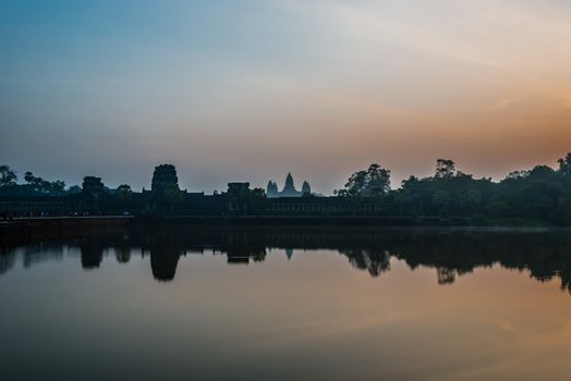 tourist entering Angkor Wat panorama viewed across the moat at Cambodia
