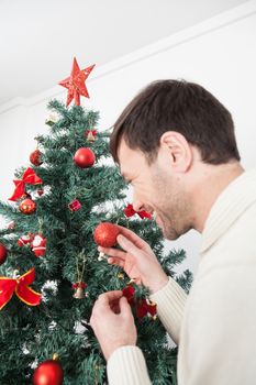 30-35, adult, artificial, background, balls, brown, caucasian, celebration, christmas, decorating, decorations, eyes, festive, garland, green, handsome, happy, holiday, male, man, men, model, old, ornaments, person, pine, pleasure, property, red, releases, santa, seasonal, smiling, sweater, tall, tradition, tree, vertical, white, winter, xmas, years, young, fun, smile, hands, hold, star