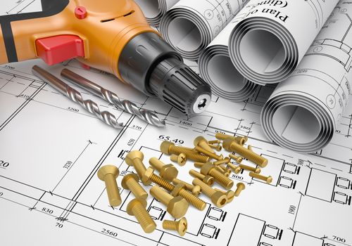 Electric screwdriver, fastening hardware, borers and scrolled drafts placed on  spread architectural drawing.  Construction business concept.
