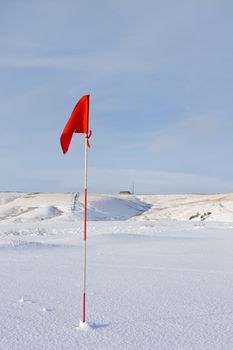 Red Golf Flag in the Snow