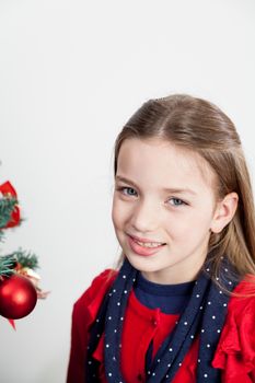 8-10, anticipation, background, backround, ball, girl, pretty, blonde, caucasian, christmas, christmastime, decorations, gift, green, hair, hold, holding, holiday, indoors, look, looking, female, model, old, one, only, present, profile, property, red, releases, side, single, smile, standing, studio, sweater, the, tree, vertical, white, winter, xmas, years