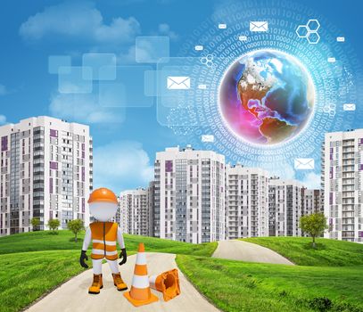 Three-dimensional man dressed as a road worker standing by traffic cones on road through green hills. High-rise buildings as backdrop. Brightly coloured planet, charts and other virtual items in sky. Elements of this image furnished by NASA