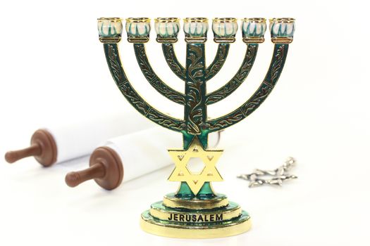 Jewish candlestick and Torah scroll in front of white background