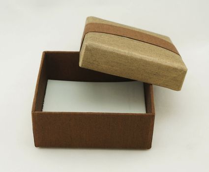 Opened gift box packaging, the exterior is made from fabric with gold and brown color.                              