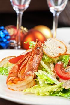 Tasty shrimp salad with vegetables on christmas table