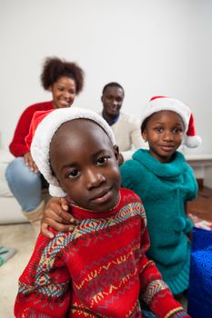 30-35, 4-6, adult, african, apartment, black, boy, celebration, childhood, children, christmas, color, colour, couple, cute, family, father, girl, happiness, happy, hat, holding, home, house, inside, lifestyle, living, love, model, mother, old, people, portrait, presents, property, releases, room, senior, sitting, smiling, sofa, together, two, vertical, years, young