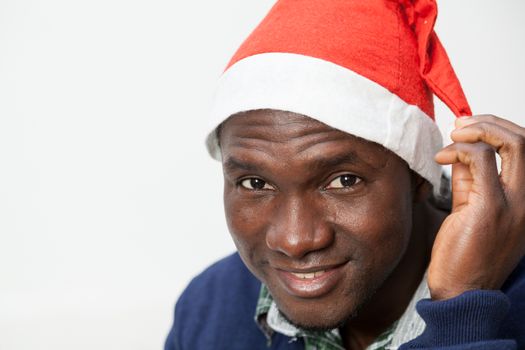 30-35, adult, african, apartment, at, attractive, black, camera, casual, christmas, cute, festive, festivity, front, happy, hat, holidays, home, homey, horizontal, house, household, inside, joyful, leisure, life, living, looking, male, man, model, old, one, person, portrait, pretty, property, releases, room, sit, sitting, smiling, sweater, time, years