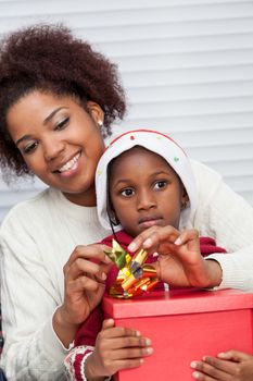 30-35, 4-6, african, apartment, attractive, beautiful, black, box, bun, child, christmas, couple, curly, daughter, decorating, family, female, gift, girl, girls, happy, hat, holding, home, homey, house, household, life, living, love, model, mother, offering, old, parent, person, pretty, property, releases, room, sitting, two, vertical, woman, years, young